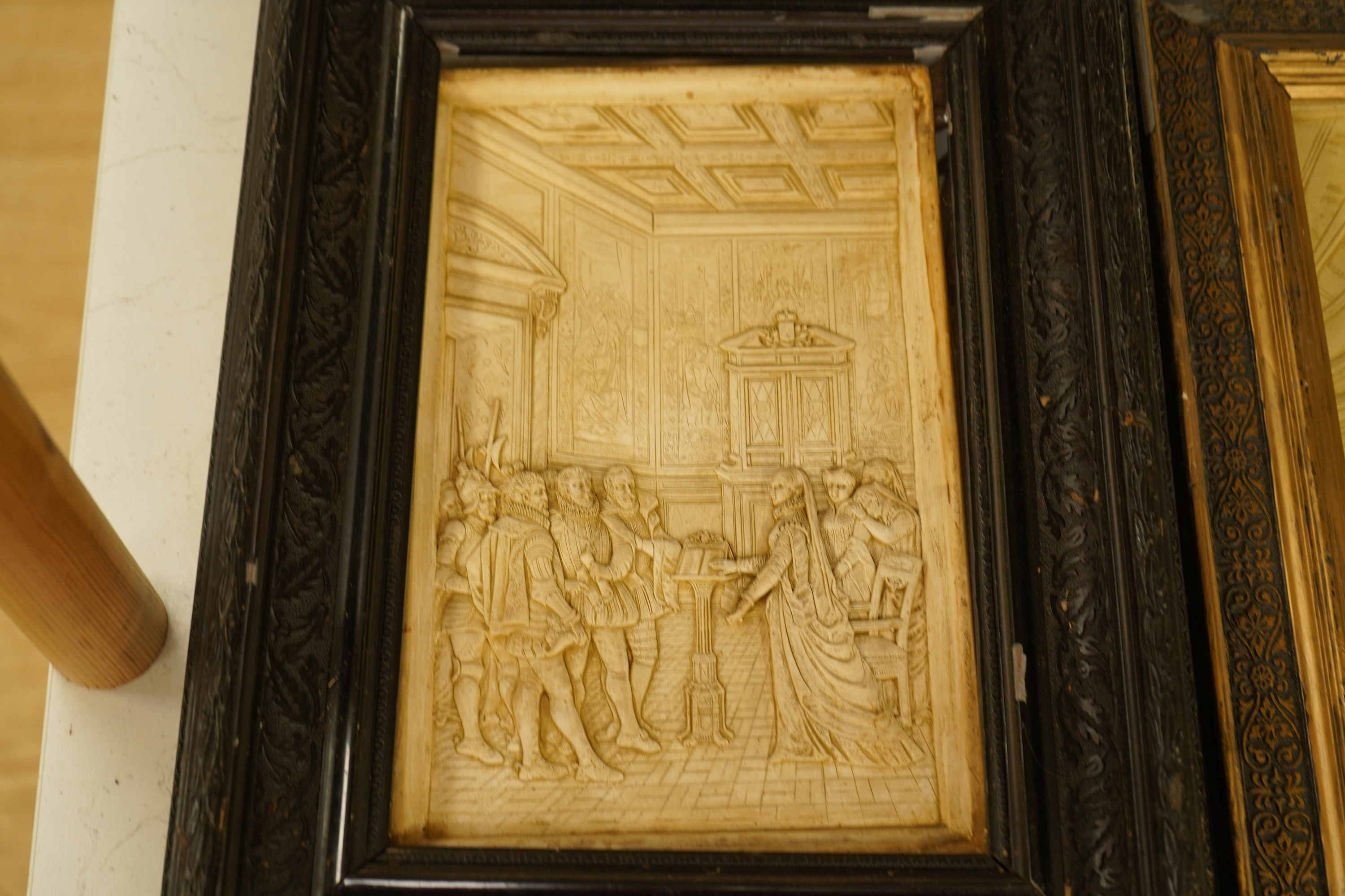 SVD., a pair of marquetry and penwork butterfly panels and a pair of relief moulded plaster panels depicting Tudor scenes, each framed, largest 41cm high